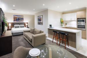 墨尔本Kimberley Gardens Hotel, Serviced Apartments and Serviced Villas的带沙发的客厅和带沙发床的厨房