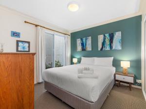金斯克里福Nautica on Marine Parade by Kingscliff Accommodation的卧室设有一张白色大床和一扇窗户。