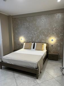 圣欧费米亚拉默齐亚B&B Lamezia Central Airport的卧室内的一张床位,墙上有两盏灯