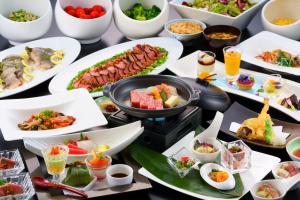 廿日市Grandvrio Hotel Miyajima Wakura - ROUTE INN HOTELS -的餐桌上放着食物和碗