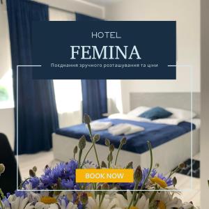 日托米尔Hotel Femina的一间卧室配有一张蓝色床单和鲜花的床
