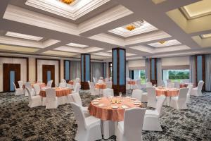 HoshiārpurFortune Park, Hoshiarpur - Member ITC's Hotel Group的宴会厅配有桌子和白色椅子