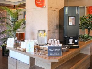 石垣岛石垣岛格兰蒂亚路线酒店的一个带咖啡壶的书架的存储台