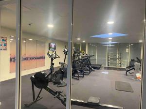 悉尼Apartment in Chiswick with Pool, sauna & Gym的健身房设有跑步机,健身房提供健身自行车