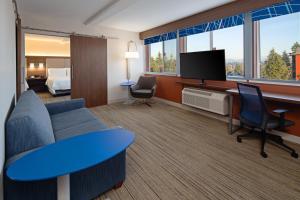 西塔科西雅图--西塔克机场智选假日酒店的酒店客房设有沙发、电视和床。