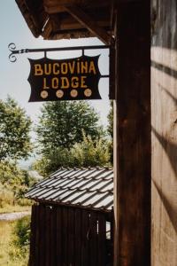 瓦马Bucovina Lodge Pension的建筑物一侧的标志