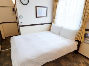 大阪Toyoko Inn Osaka Shinsaibashi Nishi的窗户客房内的一张床位