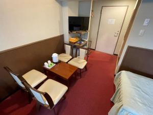 箱根油烟管道戈拉酒店 的一间设有两把椅子、一张桌子和一张床的房间