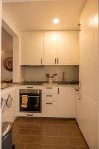 卡武埃鲁Cozy Beach Apartment W/ Sea View, Free Parking & AC的厨房配有白色橱柜和水槽