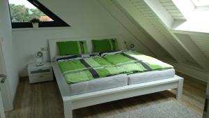 特拉森海德Ferienhaus Luise Urlaubslust Trassenheide的一间卧室配有一张带绿色枕头的床和一扇窗户