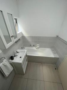 普利登堡湾X3 on Goose with Sea View的白色的浴室设有浴缸和水槽。