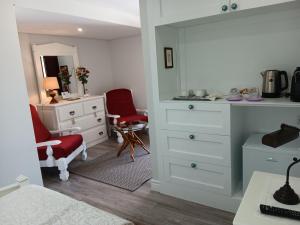 蓬德利马Casa d'Artengo的卧室配有白色梳妆台和红色椅子