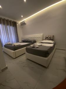 卡萨米尔Villa Mucodemi 1的两张床铺位于带墙壁的房间