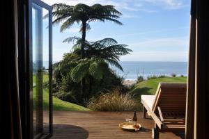 科灵伍德Adrift In Golden Bay- Absolute Beachfront Villas的客房可从门廊欣赏到海景