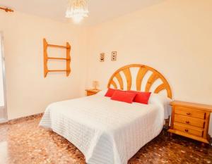 格拉纳达Apartamento Jose Enrique的卧室配有带红色枕头的大型白色床