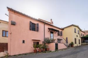 索拉诺La Tana della Volpe的街上有盆栽的粉红色房子