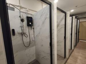 新加坡BEAT Arts Hostel at Chinatown的一间铺有白色大理石的淋浴浴室