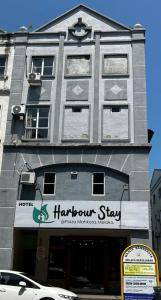 马六甲Hotel Harbour Stay的一座大型灰色建筑,上面有竖琴的标志