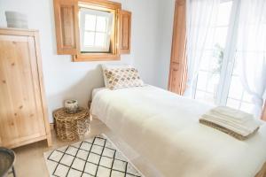 辛特拉Dreamsea Surf Guest House的卧室配有白色的床和窗户。