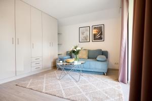 菲拉赫Pension - Ferienwohnungen Zollner的客厅配有蓝色的沙发和桌子