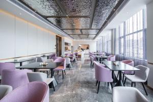 惠州惠州金山湖港惠轻居酒店的餐厅设有紫色椅子、桌子和窗户