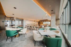 重庆重庆两江新区金科中心亚朵酒店的餐厅设有白色的桌子和绿色的椅子