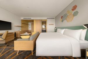顺安HIIVE by Fusion Binh Duong的酒店客房设有一张大床和一台电视机。