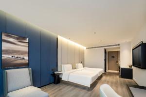 台州台州路桥亚朵酒店的卧室配有白色的床和电视