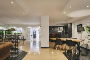 巴塞罗那阿里纳斯阿提拉姆酒店的用餐室以及带桌椅的起居室。