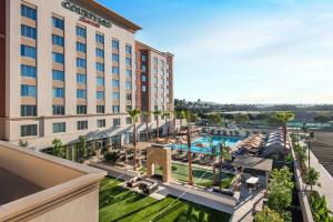 尔湾尔湾光谱万怡酒店的一张拥有游泳池和棕榈树的酒店形象