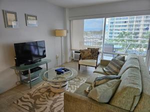 檀香山Ilikai Hotel Condo with Kitchen and Ocean View的带沙发和平面电视的客厅