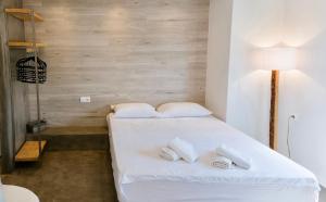 卡利斯托斯Ammos Luxury Suite的一间卧室配有带白色床单和枕头的床。