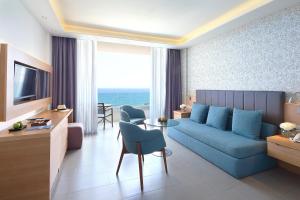 利马索尔Royal Apollonia by Louis Hotels的客厅配有蓝色的沙发和桌子