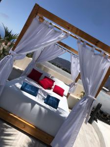 洛斯·亚诺斯·德·阿里丹Villa Tajuya的天蓬下一张带红色和蓝色枕头的床