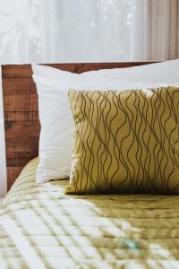 怀蒂昂格半岛汽车旅馆的一张带棕色和白色枕头的床和窗户
