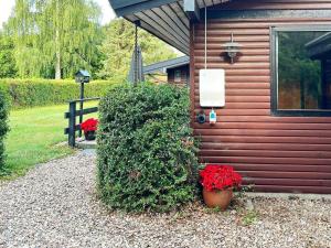 斯文堡8 person holiday home in Svendborg的前面有红花的灌木丛的房子