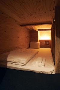 箱根Onsen Guest House Tsutaya的木制客房内的一张大床,设有窗户