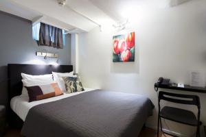 阿姆斯特丹昆汀英格兰酒店的一间卧室配有一张床、一张书桌和一幅画