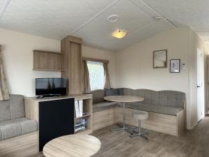 坎珀兰Chalet Lynn - Oosterschelde Camping in Kamperland的客厅配有沙发和桌子