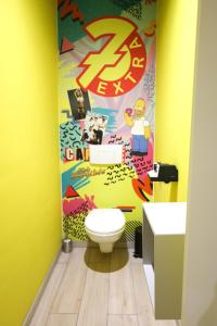 蒙斯Capsule 90's - Jacuzzi - Sauna - Flipper - Billard - Netflix - Nintendo Switch & Jeux -的一间带卫生间和黄色墙壁的浴室