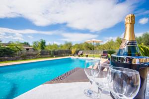 略塞塔Puri的游泳池附近的桌子上放一瓶香槟和玻璃杯