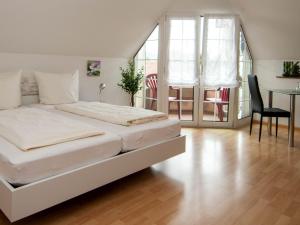 巴特塞京根Hotel Scheffelhof的卧室配有白色的床和桌椅