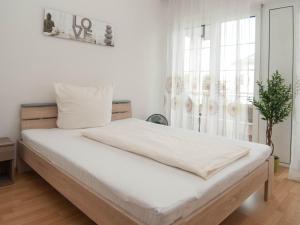 巴特塞京根Hotel Scheffelhof的一间卧室配有一张带白色床单的床和一扇窗户。