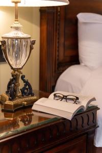 恩尼斯凯里宝尔势格酒店 - Autograph精选酒店系列的玻璃桌上的一盏灯和一本书,上面有一盏灯,上面有高端的格马克斯韦尔
