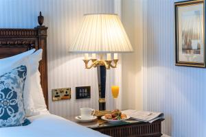 恩尼斯凯里宝尔势格酒店 - Autograph精选酒店系列的一间有台灯和一盘食物的卧房