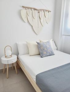 罗塔ÁTICOS ROTA Punta Candor的白色卧室配有床和椅子