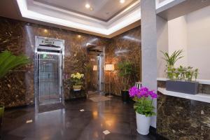 首尔LEX旅游酒店 的大堂设有电梯,墙上挂着鲜花