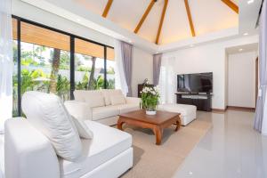 Ban Phru ChampaEscape Villas - Luxury Pool Villa at Anchan Villas的客厅配有白色家具和电视