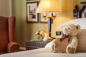 恩尼斯凯里宝尔势格酒店 - Autograph精选酒店系列的泰迪熊坐在床上,带盒子