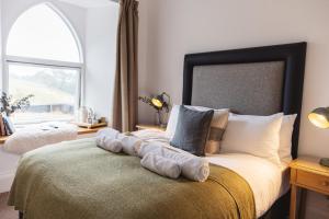 Raasay拉赛岛酿酒厂酒店的一间卧室设有一张大床和大窗户